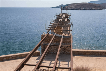 Στέκει αγέρωχη στον χρόνο, στο κύμα και την αλμύρα της θάλασσας αν και εγκαταλειμμένη η σκάλα φόρτωσης σιδηρομεταλλεύματος στα καράβια, στην περιοχή Λουτρών Κύθνου.